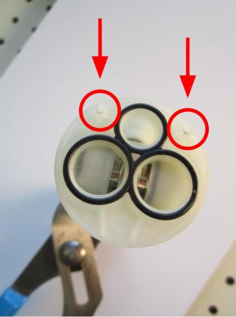 Locate the locating pins on the bottom of the cartridge and locate the corresponding holes in the faucet body.